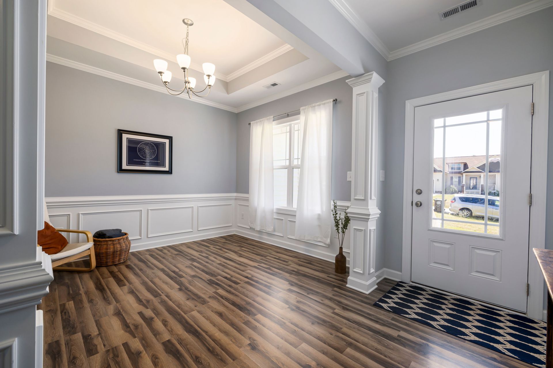 A well-lit, modern home interior featuring wood floors, elegant decor, and an inviting entrance.